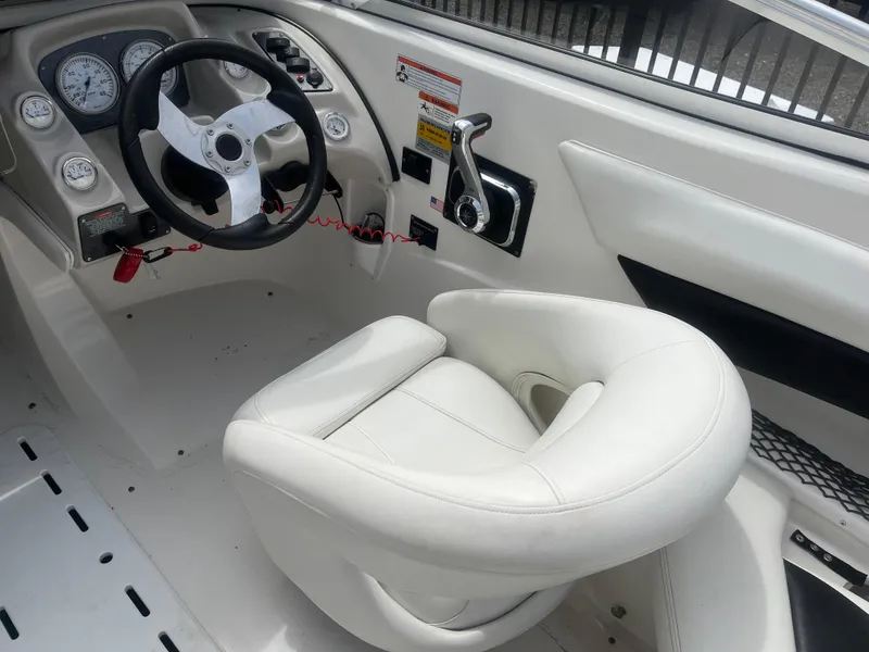 Slide: The Image of 2008 Larson 206 Sensa boat interior with white steering wheel and seat. - 7