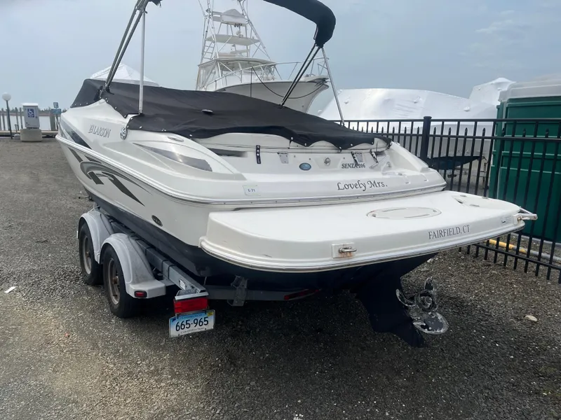 The Image of 2008 Larson 206 Sensa boat on trailer, covered and parked near a marina. - 1