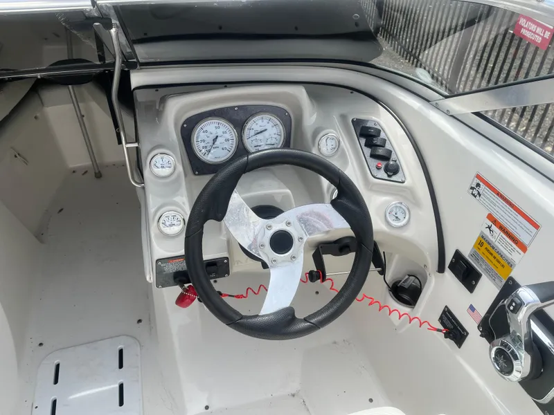 Slide: The Image of 2008 Larson 206 Sensa boat dashboard with steering wheel and gauges. - 6