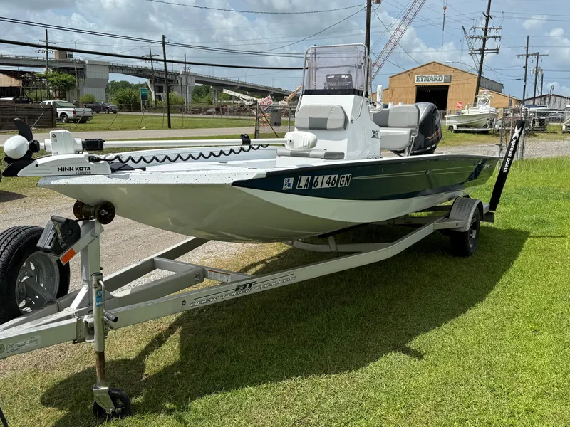 Slide: The Image of 2022 Express H20 boat on trailer, parked on grass, with industrial background. - 3