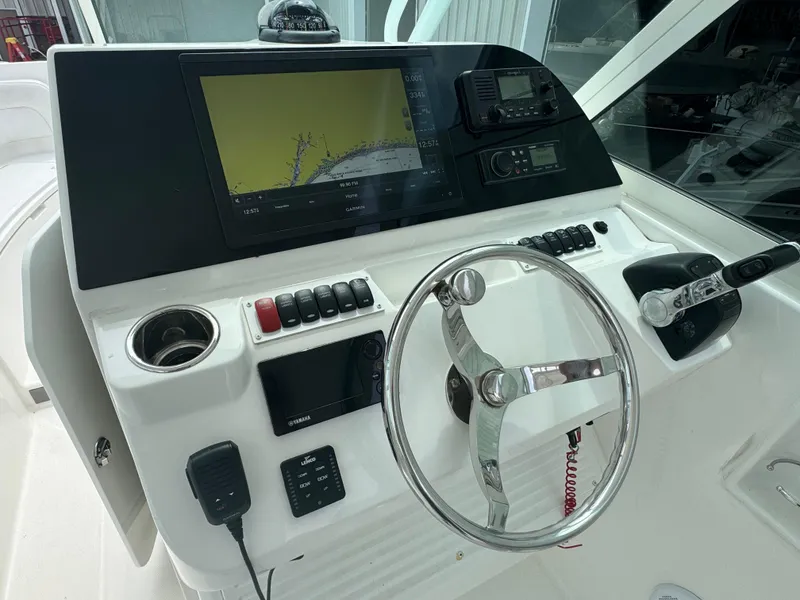 Slide: The Image of 2019 Albemarle 27 DC helm with steering wheel, navigation display, and control panel. - 18