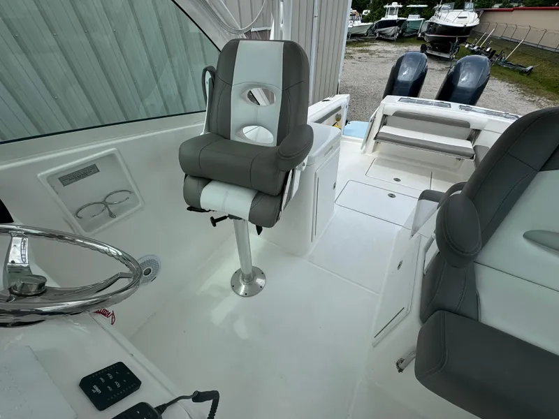 Slide: The Image of 2019 Albemarle 27 DC boat interior with gray seating and steering wheel. - 20