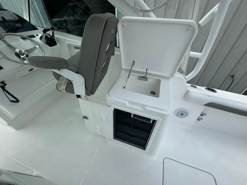 Slide: The Image of 2019 Albemarle 27 DC boat interior with helm seat and open storage compartment. - 22