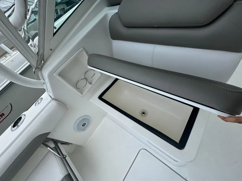 Slide: The Image of 2019 Albemarle 27 DC boat interior with storage compartment and cup holders. - 23
