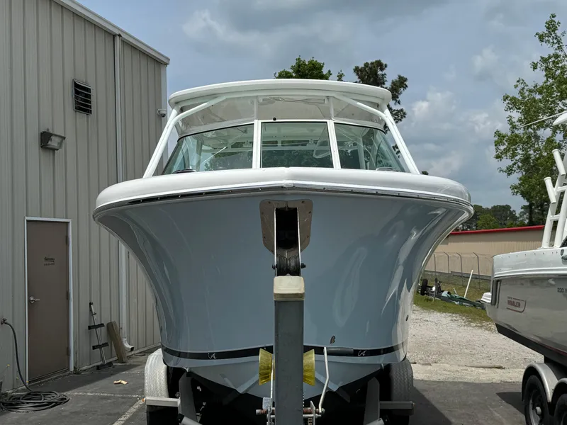 Slide: The Image of 2019 Albemarle 27 DC boat front view, parked outdoors near a building. - 8