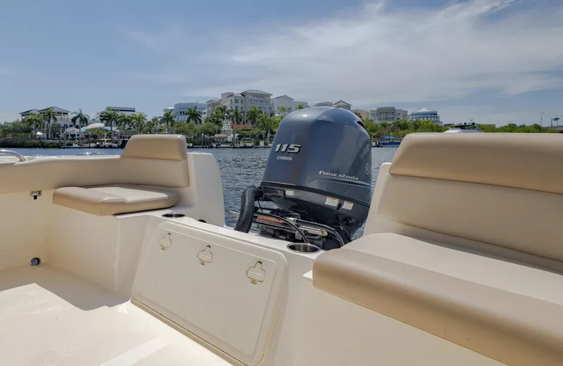 Slide: The Image of 2023 Scout 195 Sportfish boat with Yamaha 115 engine, docked near waterfront buildings. - 8
