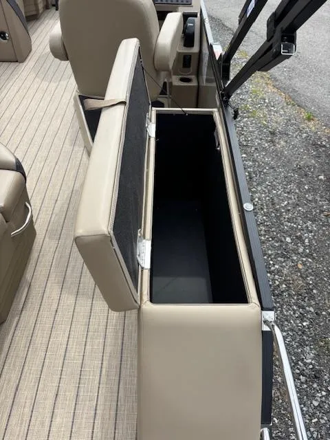 Slide: The Image of 2025 Sylvan X-3 CLZ boat storage compartment with open lid, beige interior, and sleek design. - 10