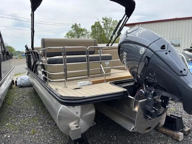 Slide: The Image of 2025 Sylvan X-3 CLZ pontoon boat with powerful outboard motor, parked outdoors. - 23