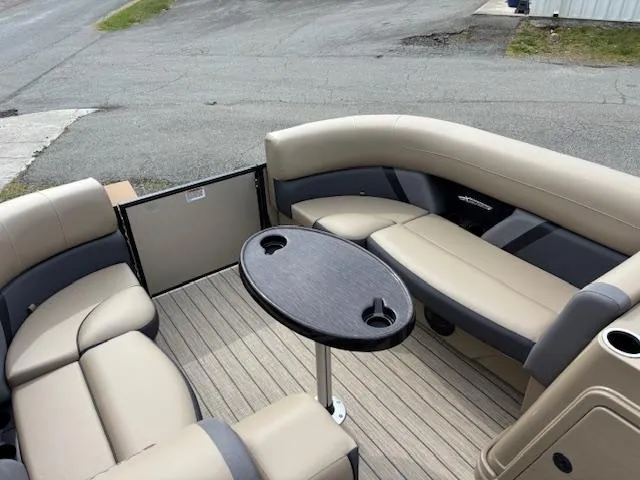 Slide: The Image of 2025 Sylvan X-3 CLZ boat interior with beige seating and a central table. - 4