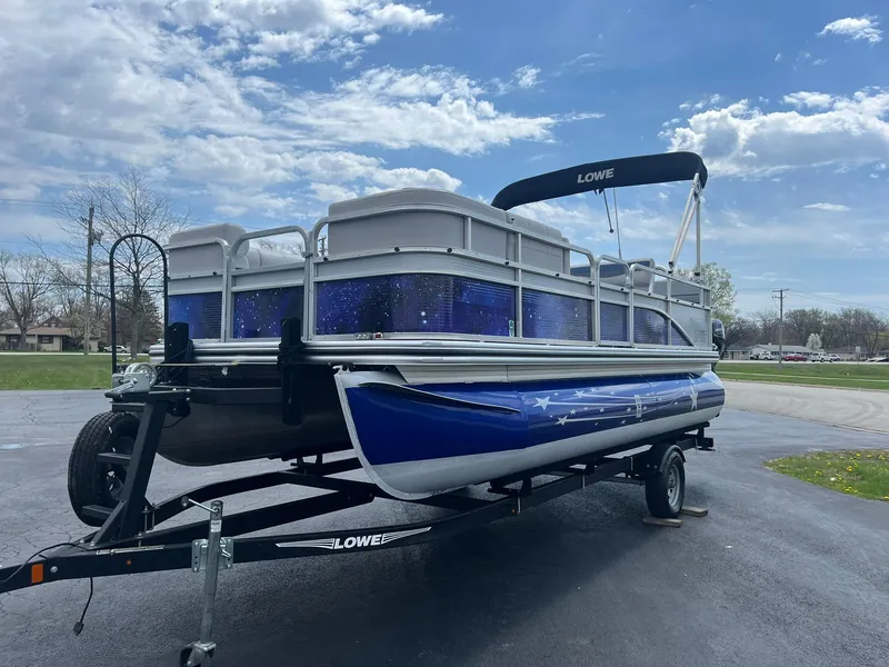 Slide: The Image of 2019 Lowe Ultra 182 Fish & Cruise pontoon boat on trailer under blue sky. - 3