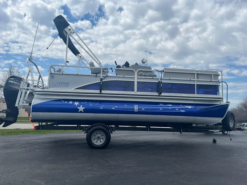 Slide: The Image of 2019 Lowe Ultra 182 Fish & Cruise pontoon boat on trailer under cloudy sky. - 5