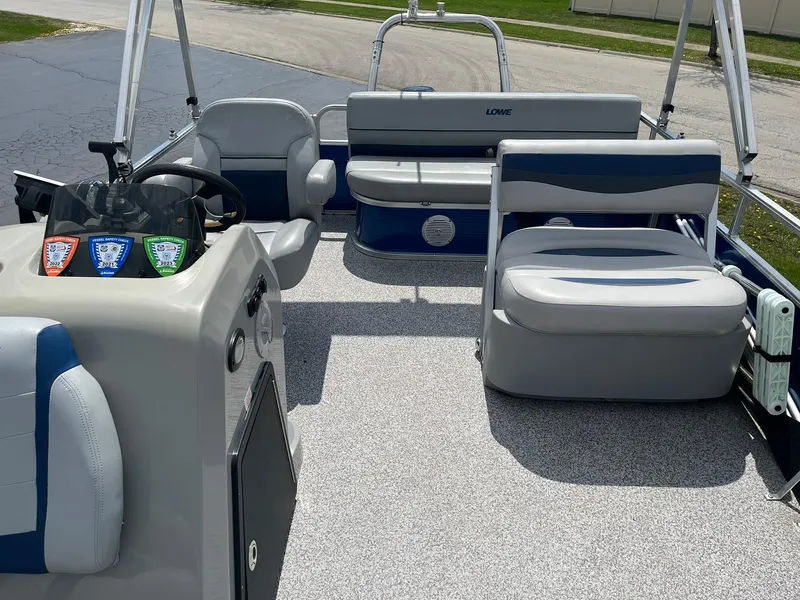 Slide: The Image of 2019 Lowe Ultra 182 Fish & Cruise pontoon boat interior with seating and steering console. - 6