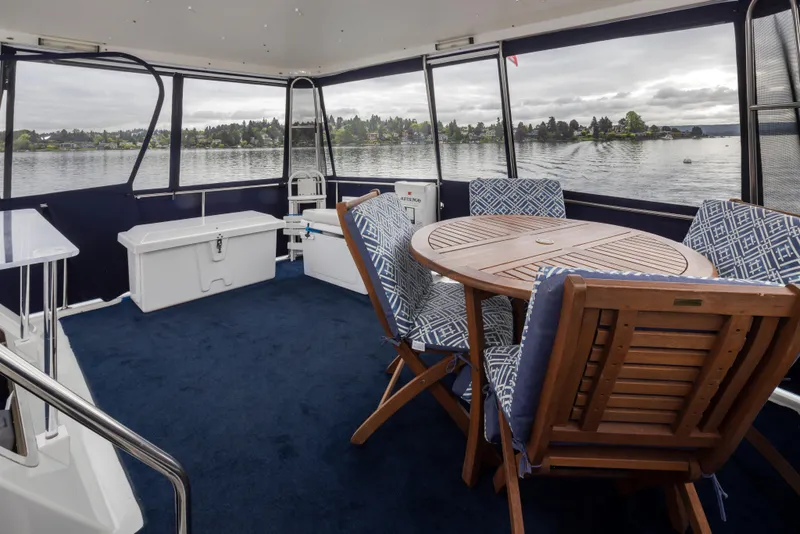 Slide: The Image of 1995 Tollycraft 45 CPMY yacht interior with round table, cushioned chairs, and scenic lake view. - 42