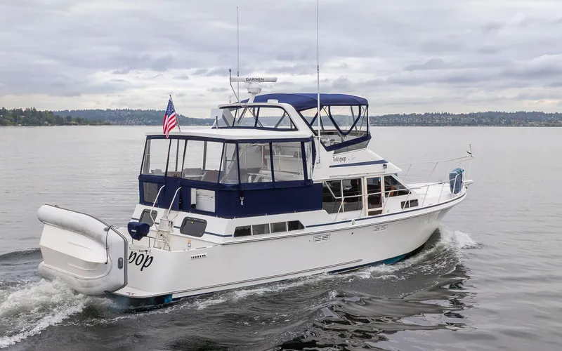 Slide: The Image of 1995 Tollycraft 45 CPMY yacht cruising on a calm lake under cloudy skies. - 7