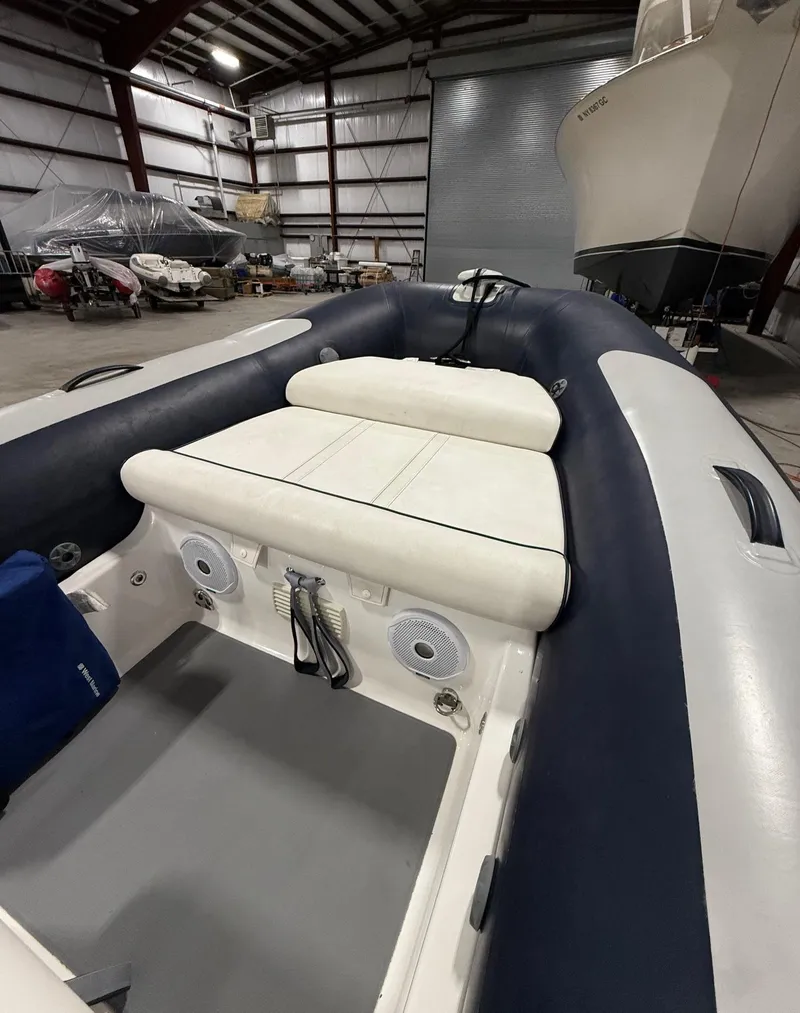 Slide: The Image of 2017 Williams Jet Tenders Sportjet 520 in a warehouse, showcasing interior seating and speakers. - 11