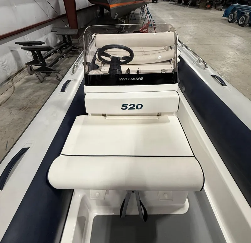 Slide: The Image of 2017 Williams Jet Tenders Sportjet 520 interior with steering console in a warehouse setting. - 13