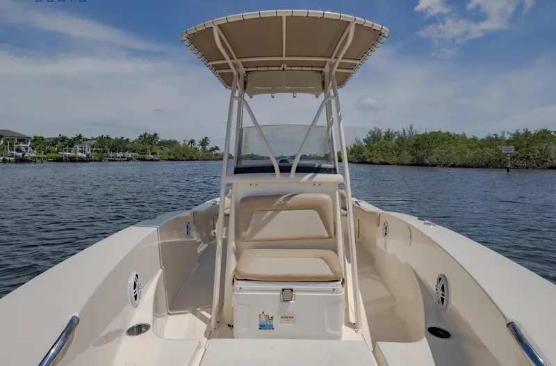 Slide: The Image of 2023 Scout 195 Sportfish boat on calm water, featuring a center console and T-top. - 5