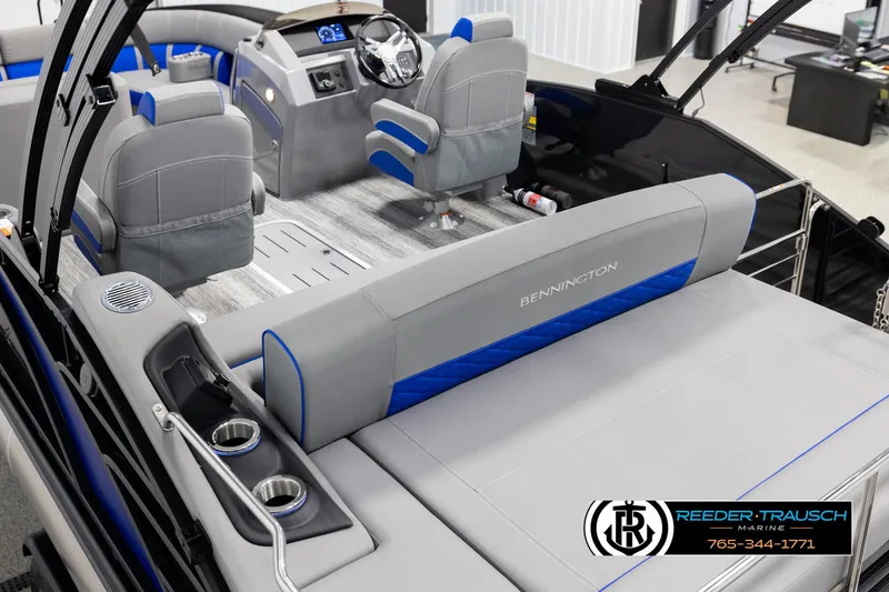 Slide: The Image of 2025 Bennington 25 LTSBSE boat interior with gray and blue seating, steering console, and cup holders. - 10