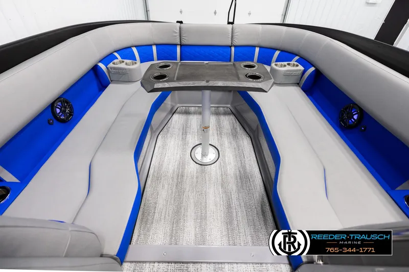 Slide: The Image of 2025 Bennington 25 LTSBSE boat interior with blue and gray seating, table, and cup holders. - 18