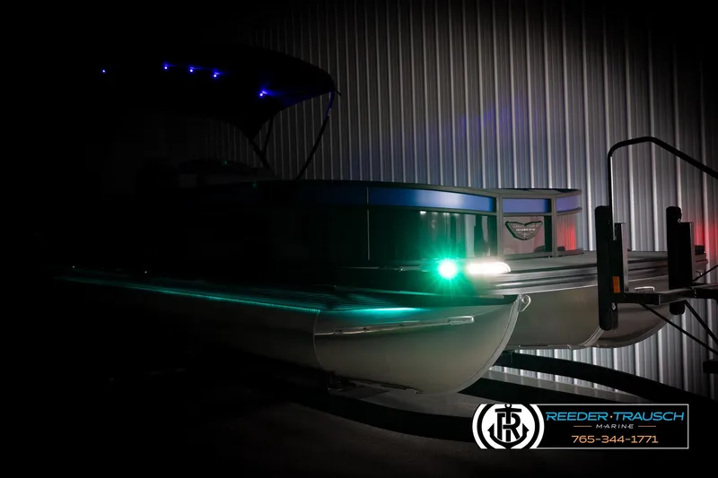 Slide: The Image of 2025 Bennington 25 LTSBSE pontoon boat with illuminated lights in a dimly lit setting. - 3
