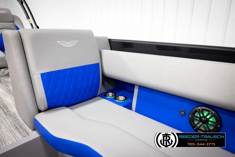 Slide: The Image of 2025 Bennington 25 LTSBSE boat interior with blue and gray seating, cup holders, and speaker. - 33