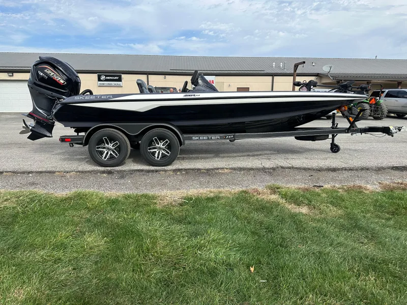 Slide: The Image of 2024 Skeeter ZXR19 boat on trailer, black and white design, parked outdoors. - 3