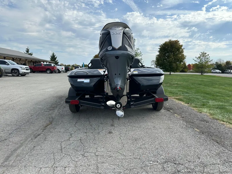 Slide: The Image of 2024 Skeeter ZXR19 boat on trailer, parked outdoors under a partly cloudy sky. - 5