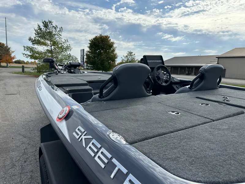 Slide: The Image of 2024 Skeeter ZXR19 boat with dual seats, parked outdoors under a cloudy sky. - 8