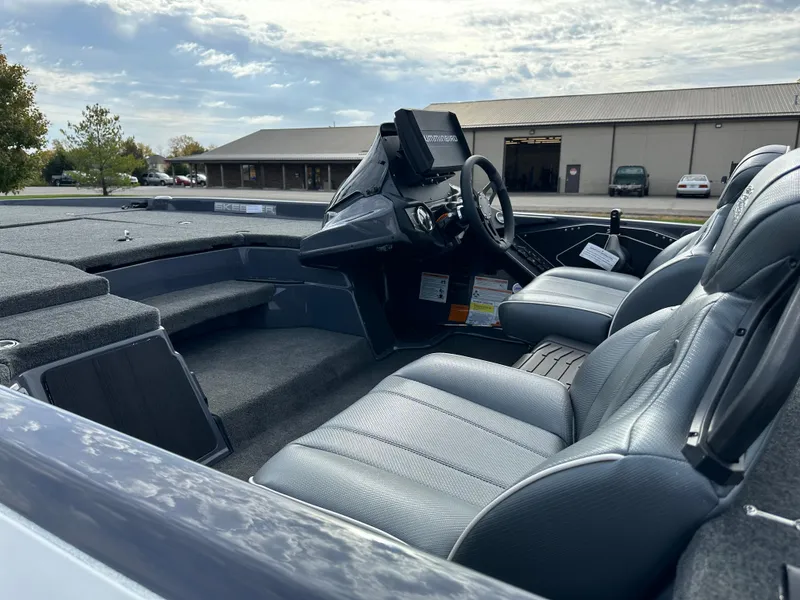 Slide: The Image of 2024 Skeeter ZXR19 boat interior with steering wheel and seating, under a partly cloudy sky. - 9