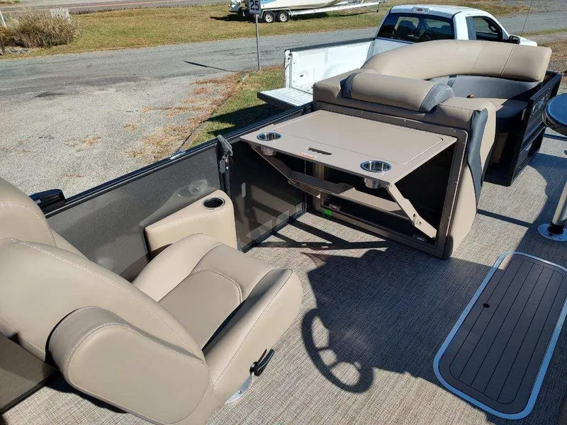 Slide: The Image of 2025 Sylvan X-3 CLZ boat interior with beige seating and foldable table. - 11