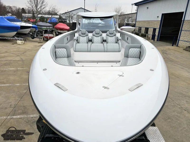 Slide: The Image of 2023 Mystic Powerboats M5200, sleek design, luxury seating, docked outdoors. - 10