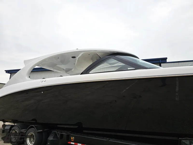 Slide: The Image of 2023 Mystic Powerboats M5200, sleek black hull, on trailer, side view. - 11