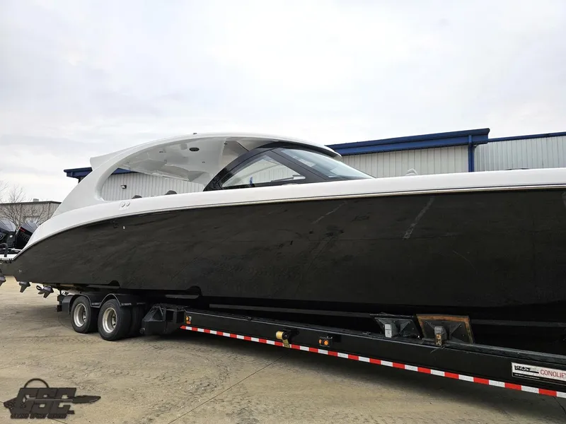 Slide: The Image of 2023 Mystic Powerboats M5200 on trailer, sleek black and white design, parked outdoors. - 12