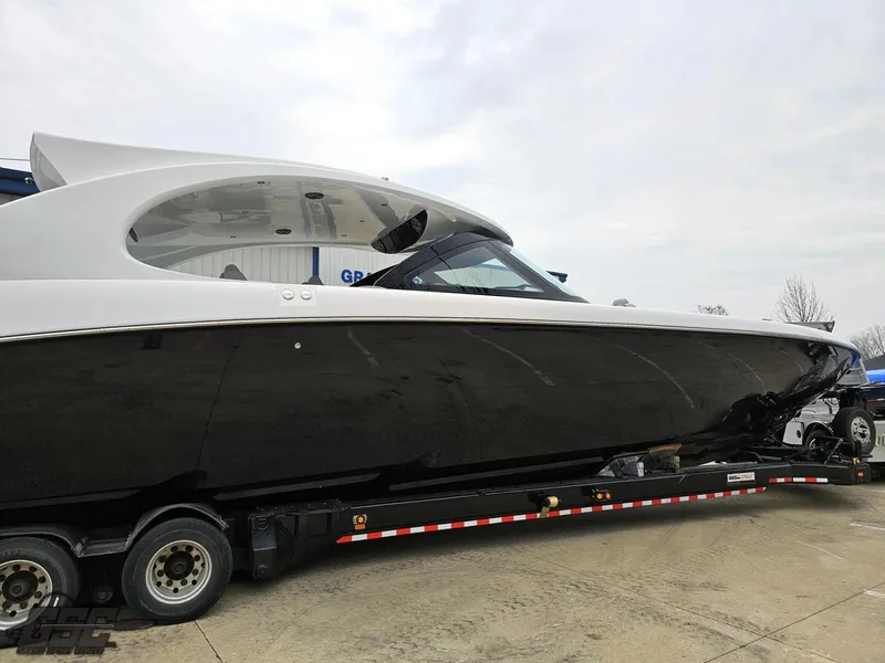 Slide: The Image of 2023 Mystic Powerboats M5200 on trailer, sleek black and white design. - 13
