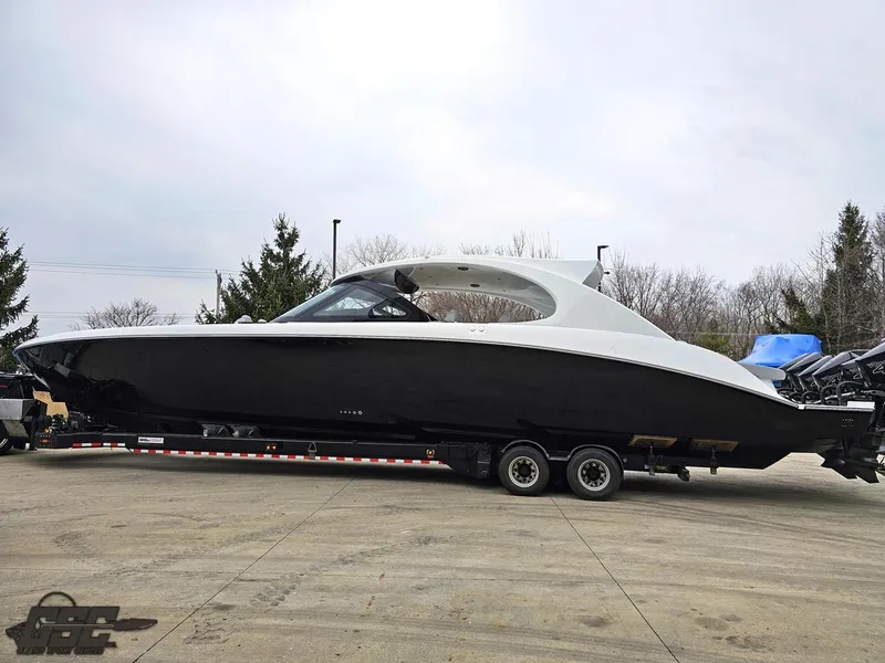 Slide: The Image of 2023 Mystic Powerboats M5200 on trailer, sleek black and white design, parked outdoors. - 19