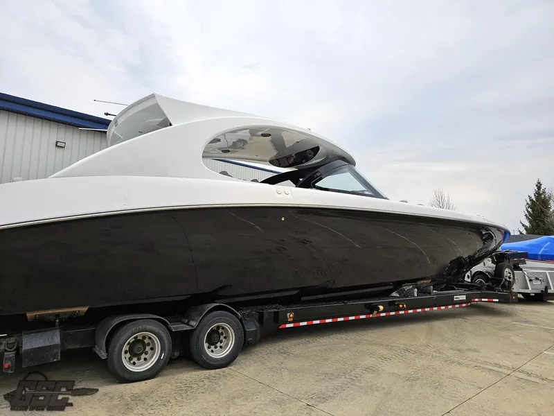 Slide: The Image of 2023 Mystic Powerboats M5200 on trailer, sleek design, black and white exterior. - 23
