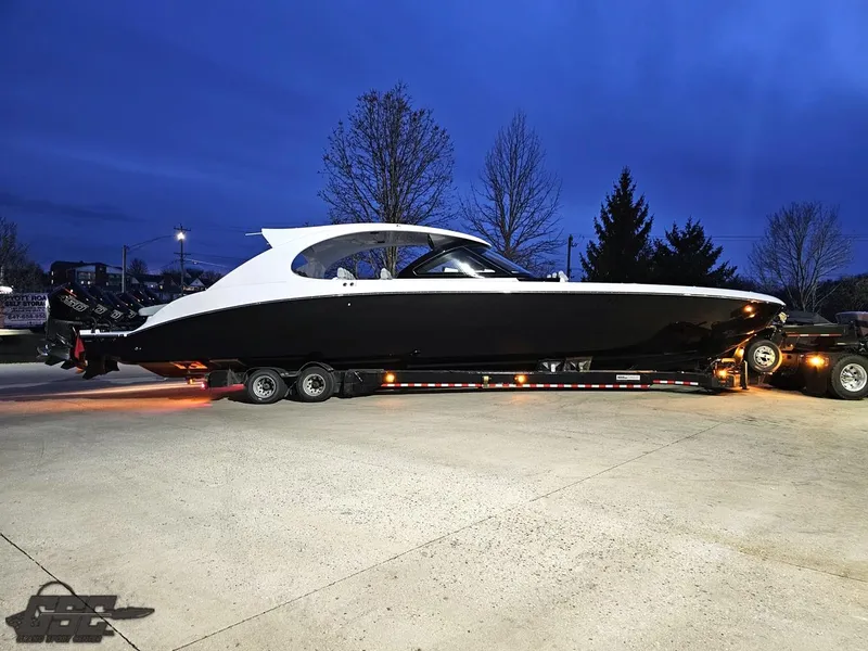 Slide: The Image of 2023 Mystic Powerboats M5200 on trailer at dusk, showcasing sleek design and modern features. - 3