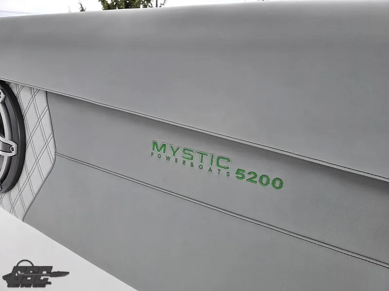 Slide: The Image of 2023 Mystic Powerboats M5200 logo on sleek gray surface. - 33