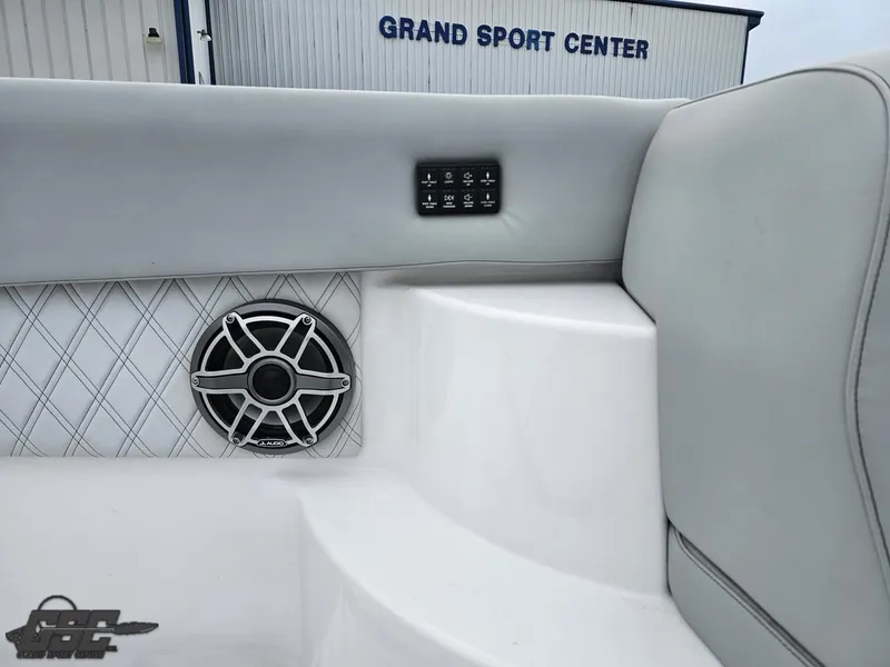 Slide: The Image of 2023 Mystic Powerboats M5200 interior with speaker and control panel, Grand Sport Center backdrop. - 46