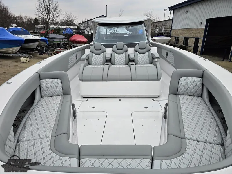 Slide: The Image of 2023 Mystic Powerboats M5200 with luxurious seating and sleek design in a marina setting. - 49