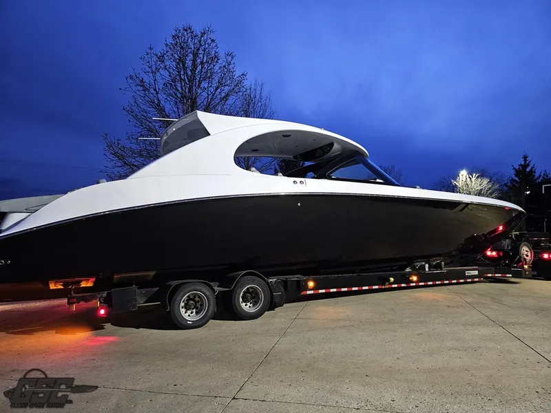 Slide: The Image of 2023 Mystic Powerboats M5200 on trailer at dusk, showcasing sleek design and modern features. - 6