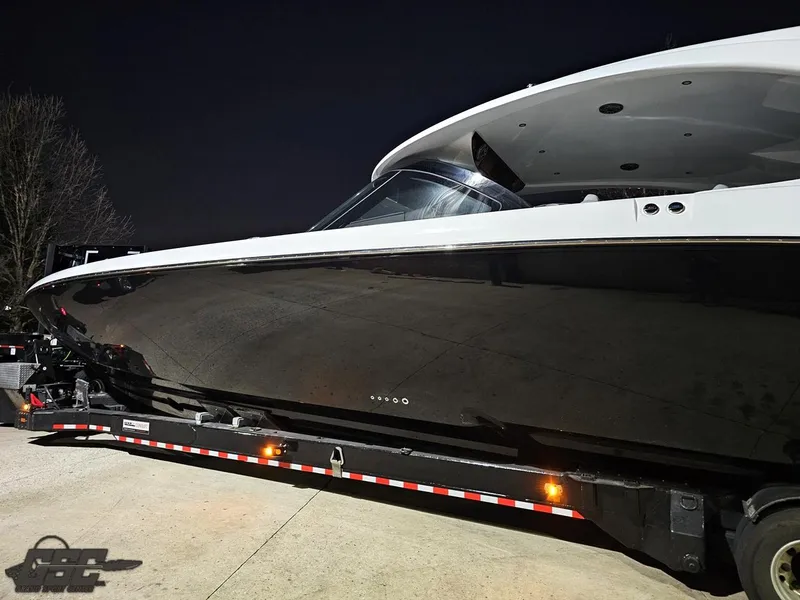 Slide: The Image of 2023 Mystic Powerboats M5200 on trailer at night, sleek black hull design. - 8