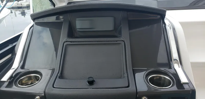 Slide: The Image of 2016 Monterey 360 Sport Coupe dashboard with cup holders and storage compartment. - 21