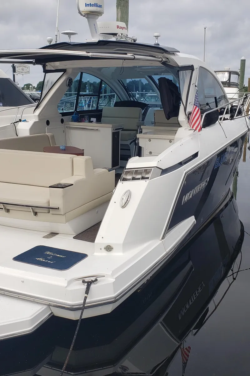 Slide: The Image of 2016 Monterey 360 Sport Coupe yacht docked, featuring sleek design and American flag. - 4