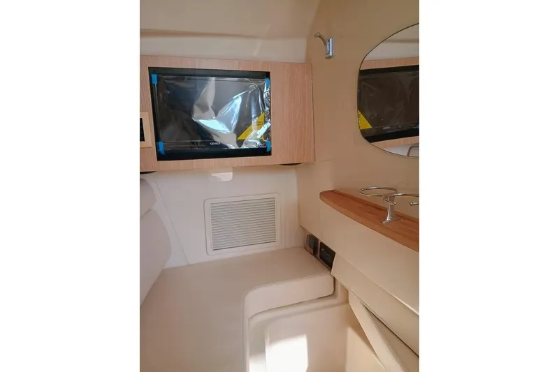 Slide: The Image of 2025 Grady-White Freedom 345 cabin interior with TV and mirror. - 13