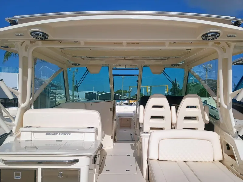 Slide: The Image of 2025 Grady-White Freedom 345 boat interior with seating and helm, under clear blue sky. - 7