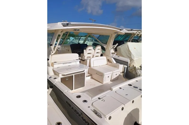 Slide: The Image of 2025 Grady-White Freedom 345 boat interior with seating and storage under clear blue sky. - 8