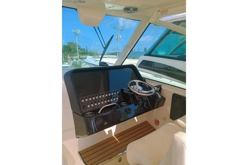 Slide: The Image of 2025 Grady-White Freedom 345 boat helm with modern controls and steering wheel. - 9