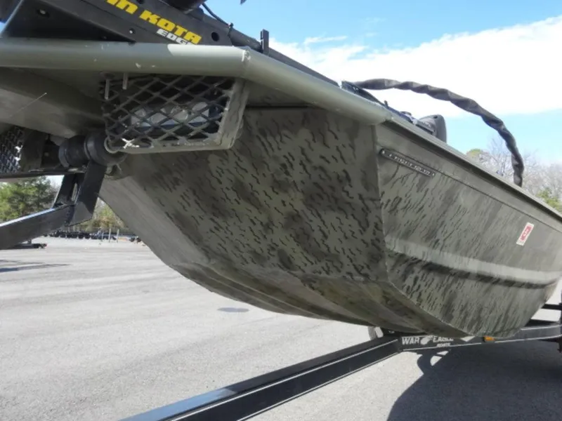 Slide: The Image of 2014 War Eagle 1542 boat on trailer, camo pattern, parked outdoors. - 12