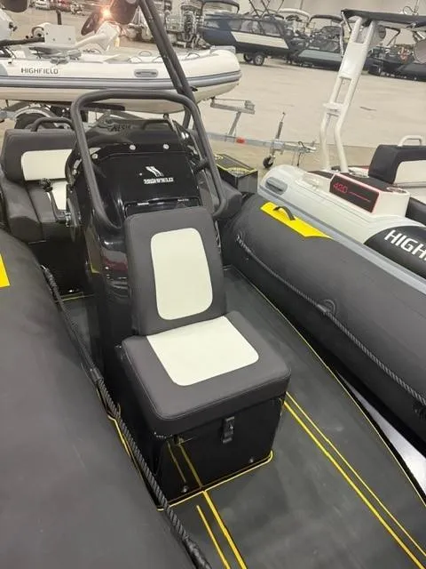 Slide: The Image of 2025 Highfield Velox 420 boat interior with black and white seating in a showroom. - 11